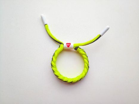 A bracelet with a heart lies on a white background.