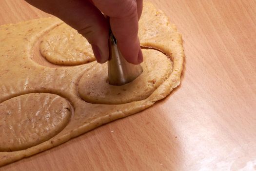 Cutting cookies from the dough and preparing for bake in the electrical stowe