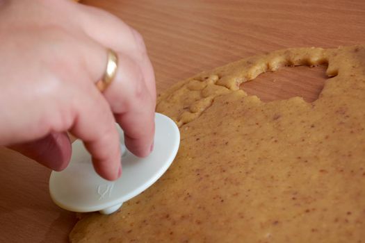 Cutting cookies from the dough and preparing for bake in the electrical stowe