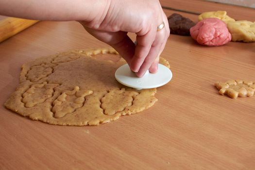 Cutting cookies from the dough and preparing for bake in the electrical stowe