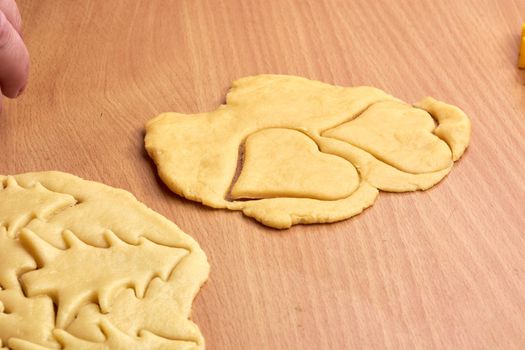 Cutting cookies from the dough and preparing for bake in the electrical stowe