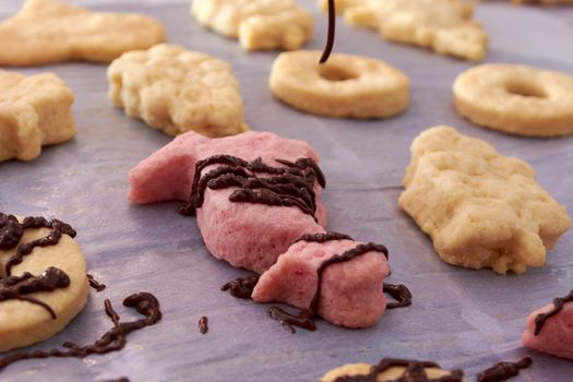 Pouring chocolate on just baked christmas cookies