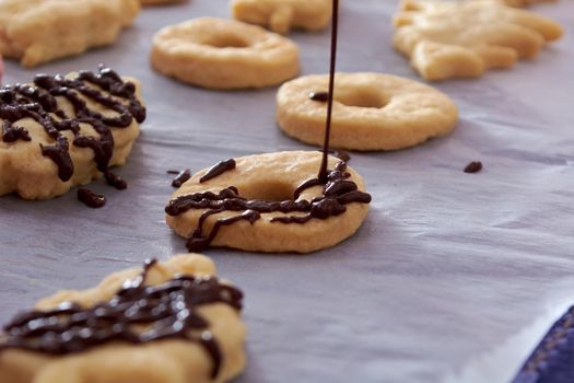 Pouring chocolate on just baked christmas cookies