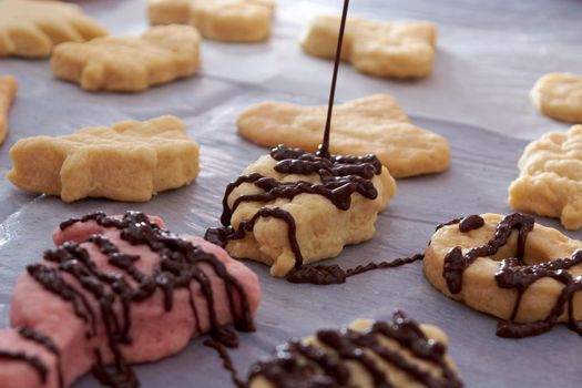 Pouring chocolate on just baked christmas cookies