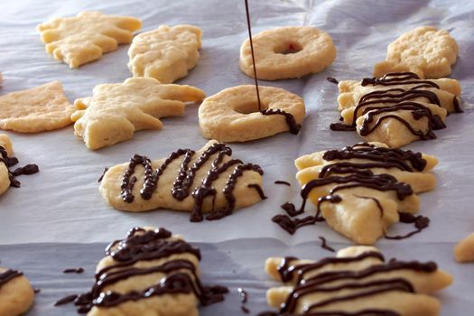 Pouring chocolate on just baked christmas cookies