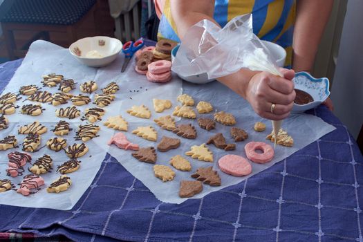 Pouring chocolate on just baked christmas cookies