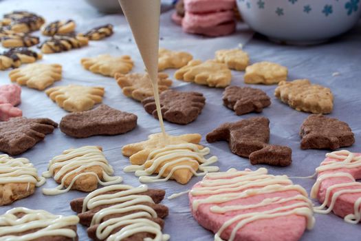 Pouring chocolate on just baked christmas cookies