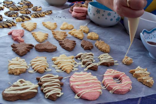 Pouring chocolate on just baked christmas cookies