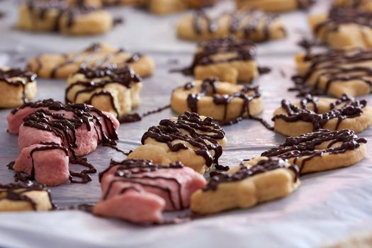 Pouring chocolate on just baked christmas cookies