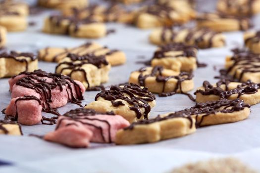 Pouring chocolate on just baked christmas cookies