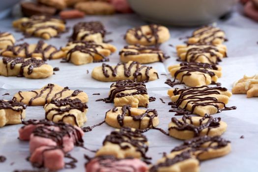 Pouring chocolate on just baked christmas cookies