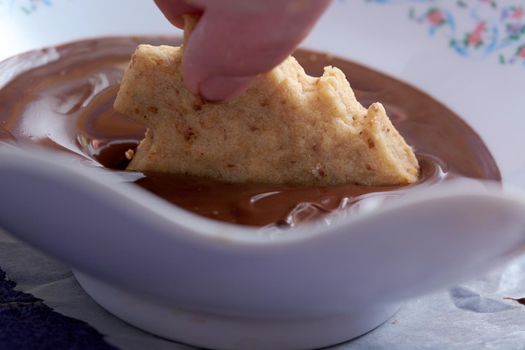 Pouring chocolate on just baked christmas cookies