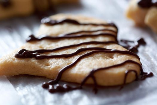 Pouring chocolate on just baked christmas cookies