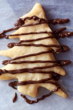 Pouring chocolate on just baked christmas cookies