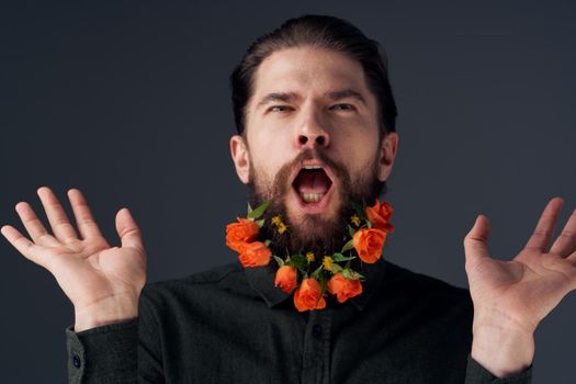 Portrait of a bearded man flowers decoration romance close-up black background. High quality photo