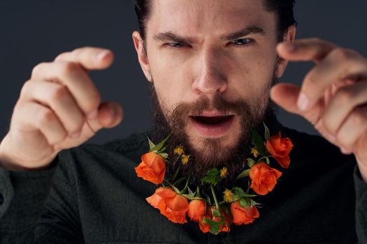 Portrait of a bearded man flowers decoration romance close-up black background. High quality photo