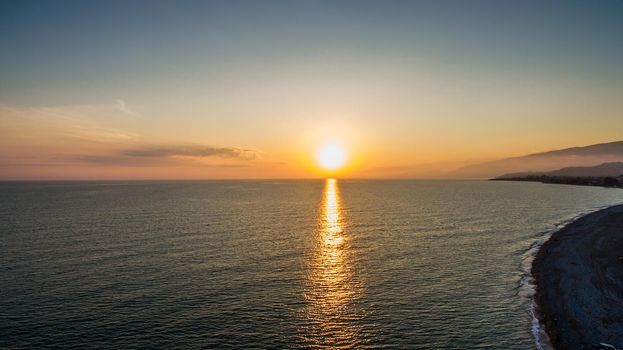 sunset over water surface of the sea from the height of bird flight