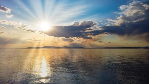 Seascape with beautiful sun at sunset reflected in the sea. Travel and tourism.