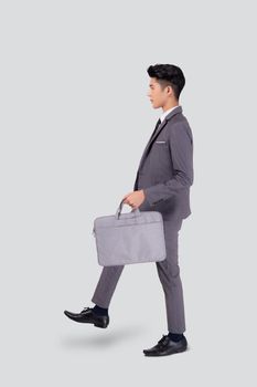 Young asian business man in suit walking movement holding bag isolated on white background, portrait of executive or manager, happy businessman holding briefcase, male with confident for success.