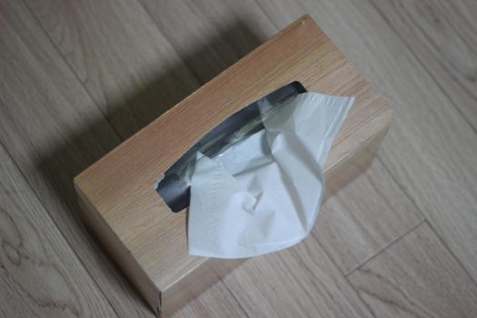 Tissue box of white facial tissue paper on wooden table