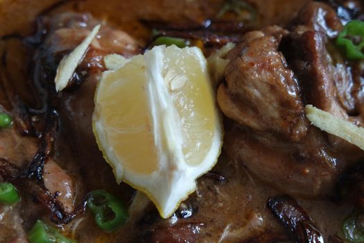 Closeup view of traditional Pakistani Haleem dish with salad and Lemon juice.