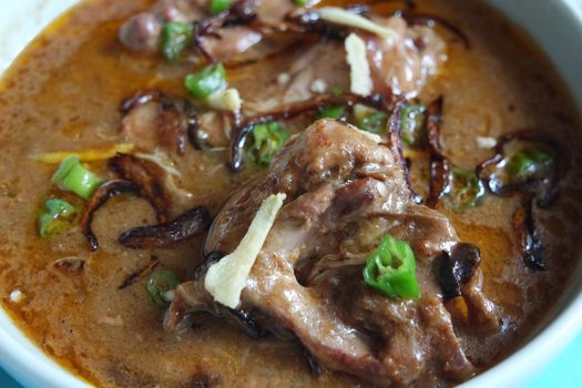 Closeup view of traditional Pakistani Haleem dish with salad and Lemon juice.