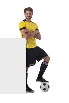 Full length portrait of young soccer player with football and billboard isolated on white background