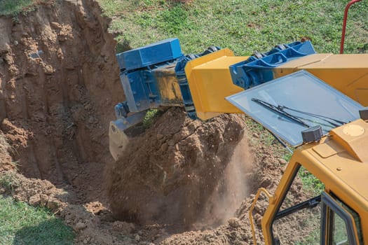 Bucket excavator digs a pit in the ground. Stock image
