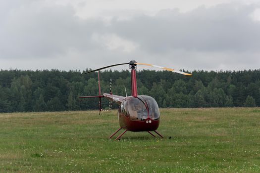Minsk, Belarus - 07/25/2018: Helicopter on the green lawn of the airfield. Stock photo.