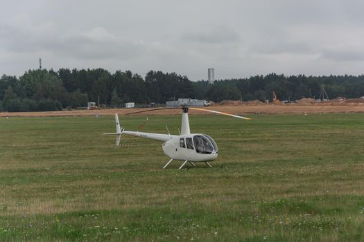 Minsk, Belarus - 07/25/2018: Helicopter on the green lawn of the airfield. Stock photo.