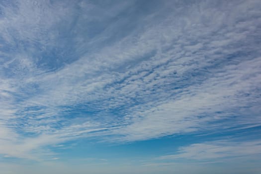 Cirrus clouds in a blue sky. Stock photo.