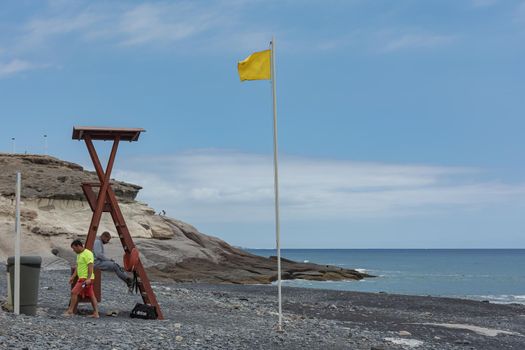 Tenerife, Spain - 05/110/2018: Lifeguards on a deserted beach and a yellow flag. Stock photo