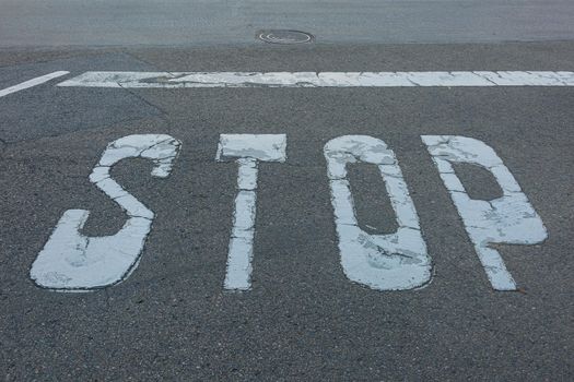 STOP sign and stop line are marked on the asphalt of the roadway. Stock photo