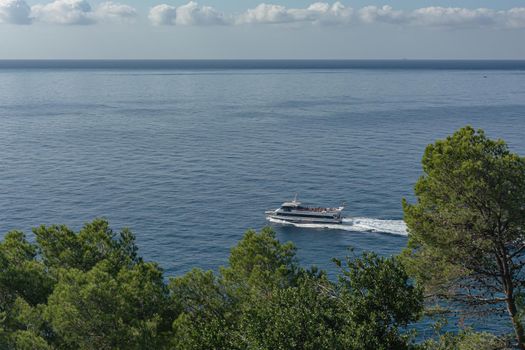 Spain, Lloret De Mar-10/02/2019: Tourist boat on the horizon and Cumulus clouds. Stock photo