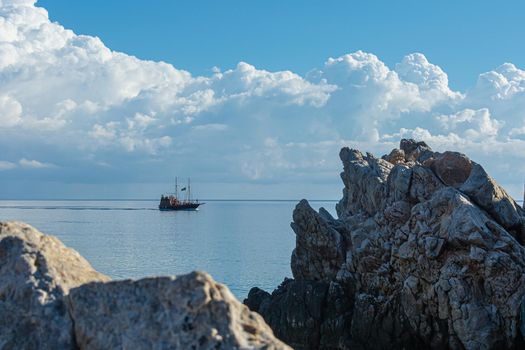 Greece, Crete - 09/29/2015 - 10/02/2019: Tourist boat on the background of the horizon and Cumulus clouds. Stock photo