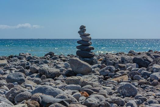 Seascape. Pyramid of stones on a rocky shore against the sea. Stock photography