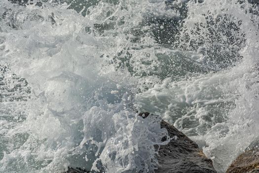 A spray of water. Waves break on coastal rocks and turn into spray. Stock photo