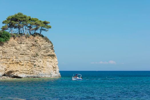 Seascape. Pleasure boat near high island. Stock photo