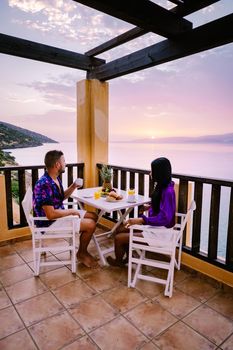 couple men and woman watching sunset over the ocean of Crete Greece Europe