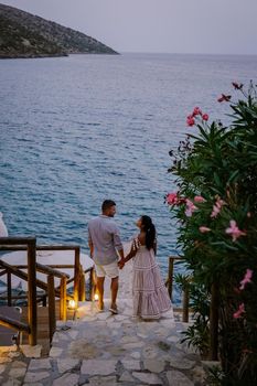 couple men and woman watching sunset over the ocean of Crete Greece Europe