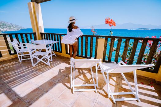 mid age Asian woman in loungers on a tropical beach of Crete Greece. Europe