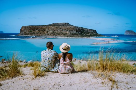 Crete Greece, Balos lagoon on Crete island, Greece. Tourists relax and bath in crystal clear water of Balos beach. Greece, couple men and woman visiting the beach