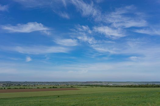 Natural landscape with hills against blue sky with white clouds.