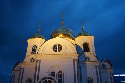 Christian Church against the evening sky lit by the rays of searchlights in the city of Krasnodar