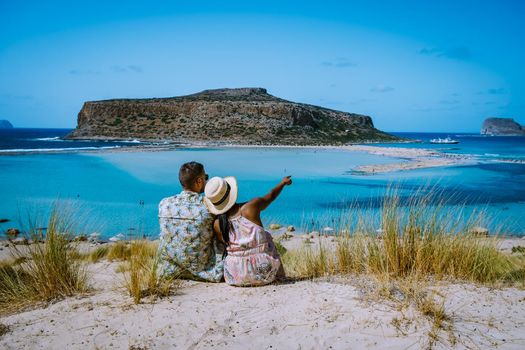 Crete Greece, Balos lagoon on Crete island, Greece. Tourists relax and bath in crystal clear water of Balos beach. Greece, couple men and woman visiting the beach