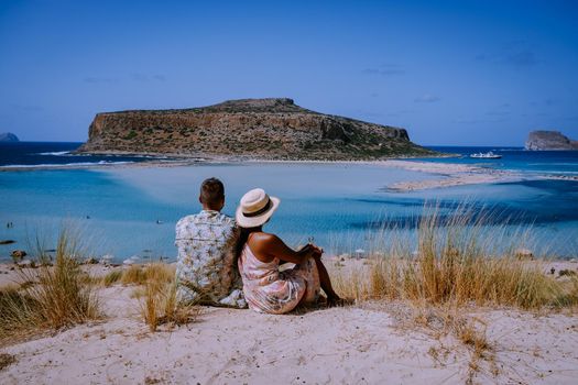 Crete Greece, Balos lagoon on Crete island, Greece. Tourists relax and bath in crystal clear water of Balos beach. Greece, couple men and woman visiting the beach