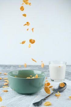 Healthy Breakfast-Cornflakes and Milk Splash on blue background.