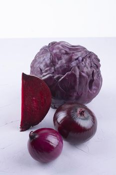 purple cabbage, onions, beetroot on purple and white.