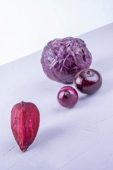 purple cabbage, onions, beetroot on purple and white.