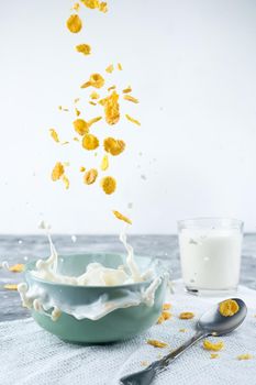 Healthy Breakfast-Cornflakes and Milk Splash on blue background.